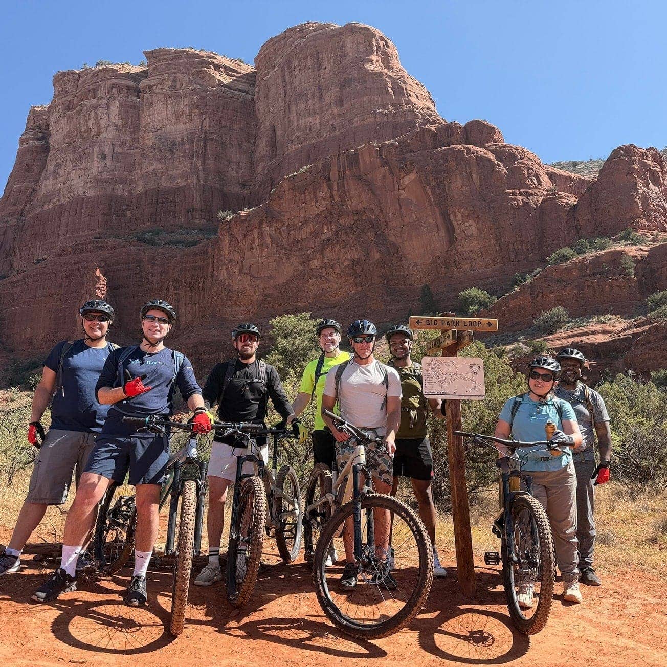 Scimitar team members mountain biking on a red rock trail.