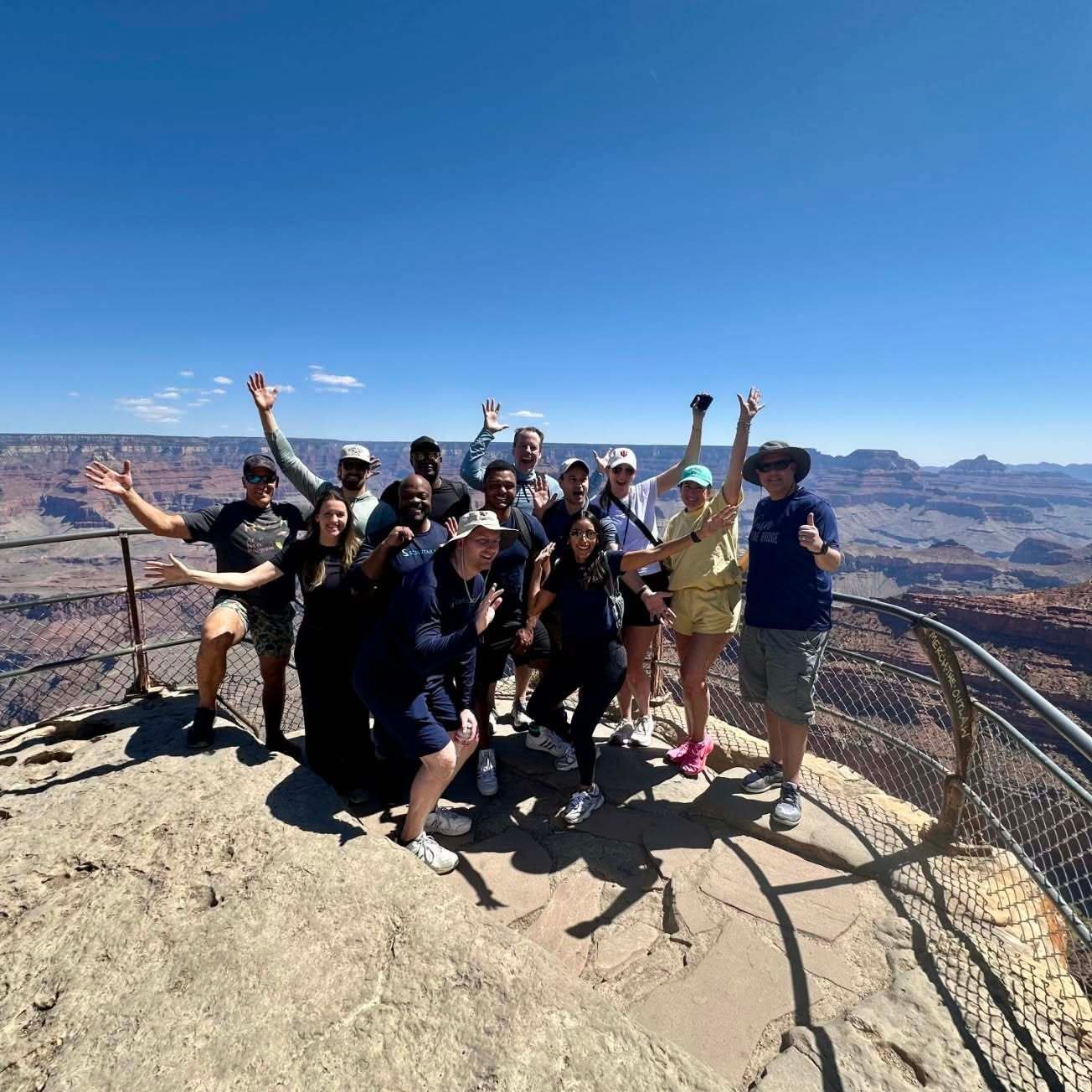Scimitar team members celebrating together at a Grand Canyon overlook.